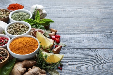 Photo of Different natural spices and herbs on grey wooden table. Space for text