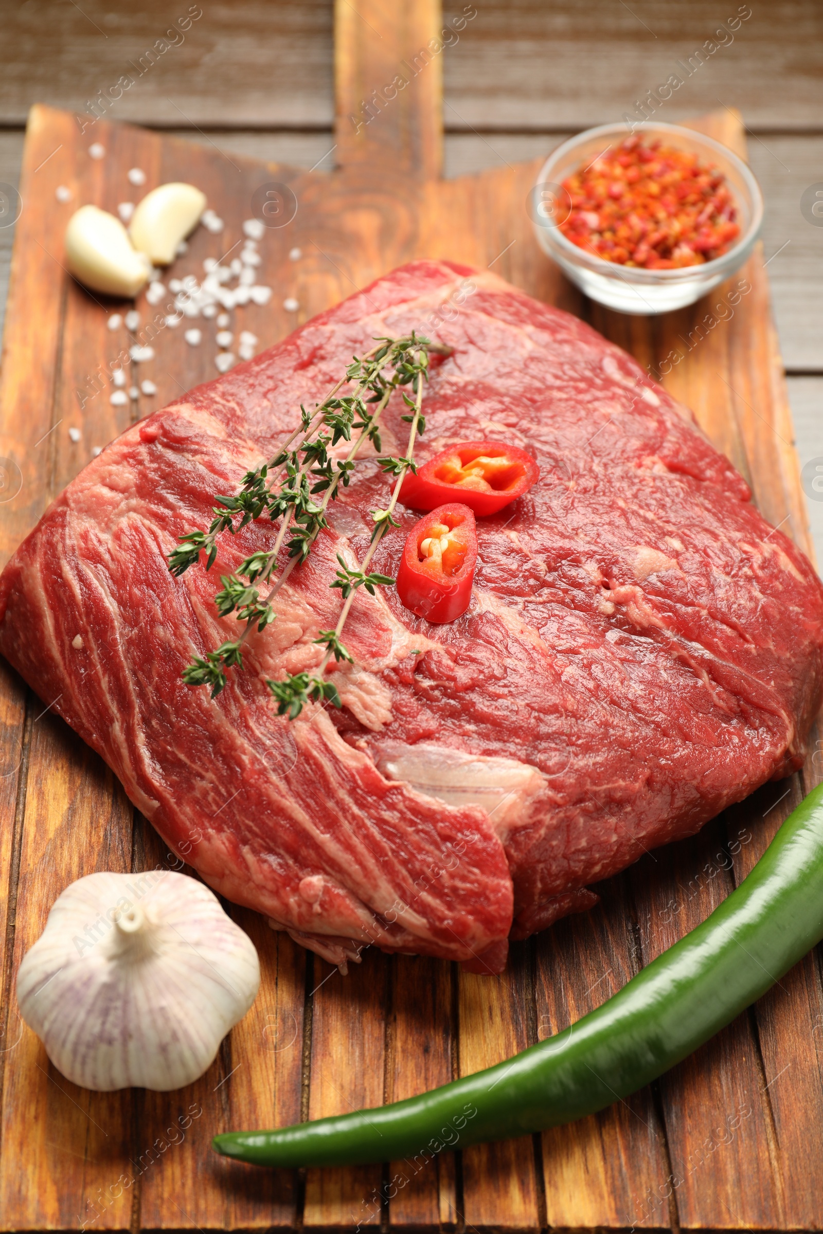 Photo of Fresh raw beef cut with spices on table