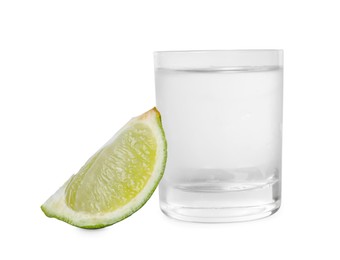 Photo of Shot glass of vodka and lime isolated on white