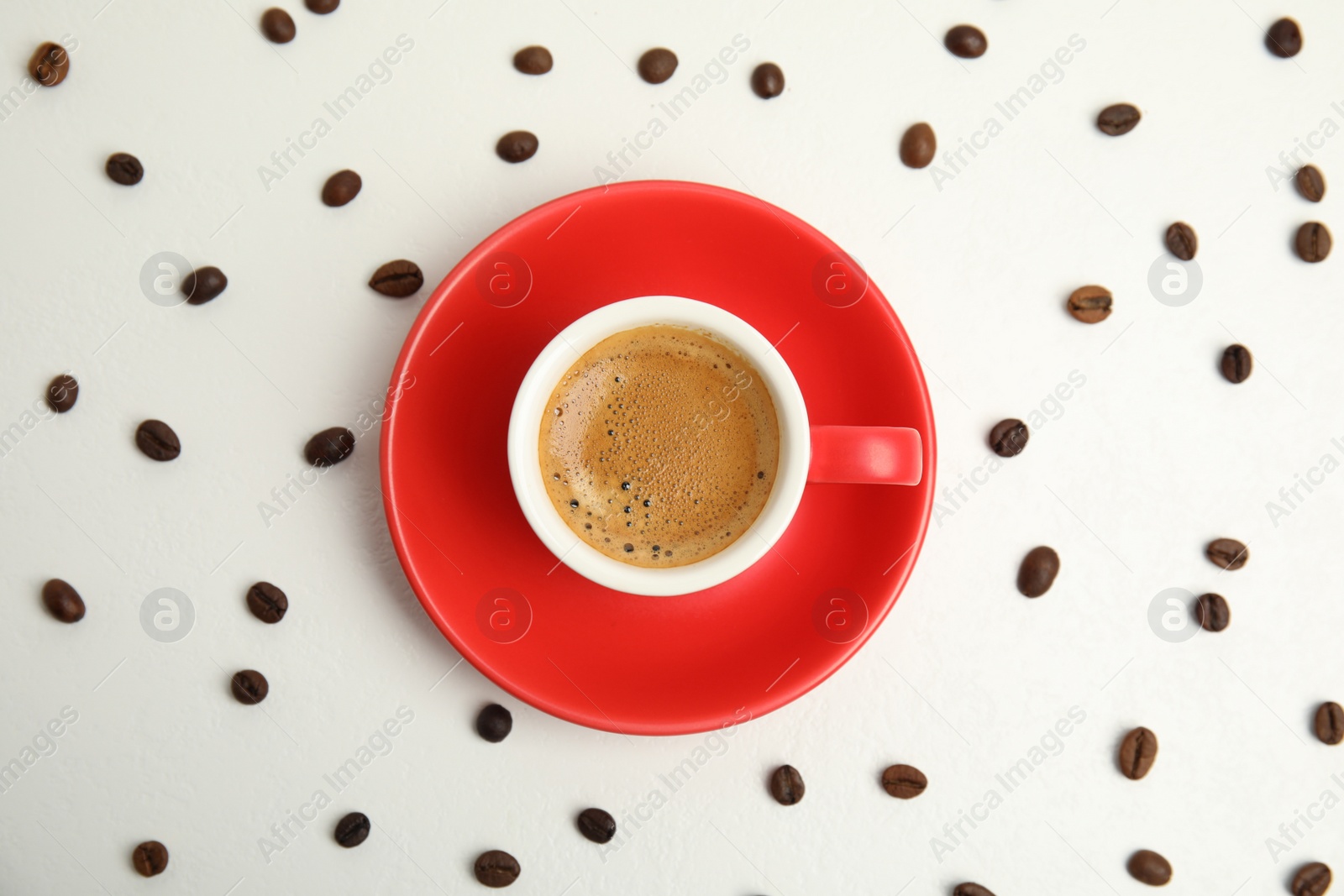 Photo of Cup of tasty coffee and beans isolated on white, top view