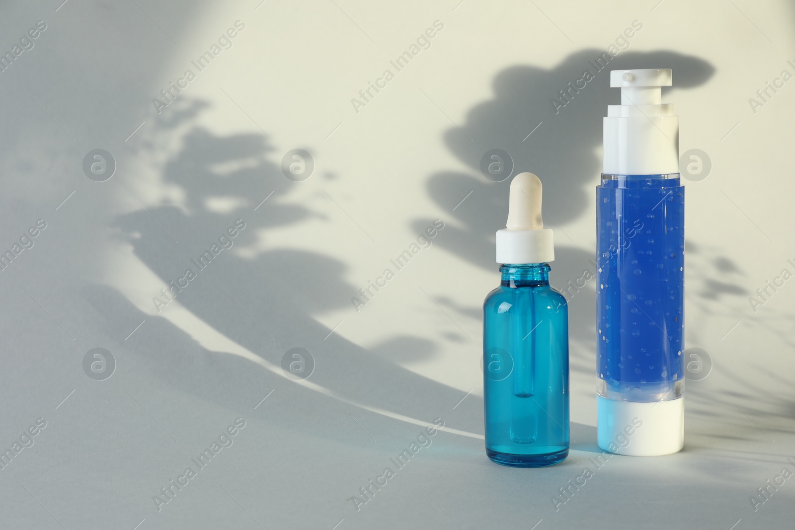 Photo of Bottles of cosmetic products on white background. Space for text