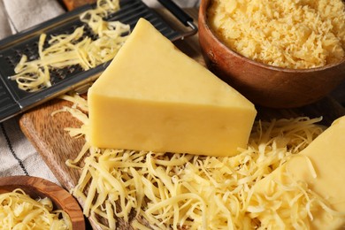 Photo of Grated and whole piece of cheese on table, closeup