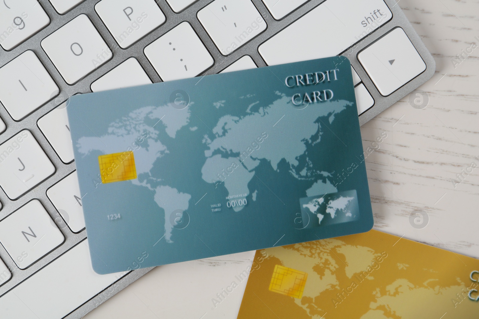 Photo of Online payment. Credit cards and keyboard on white wooden table, flat lay