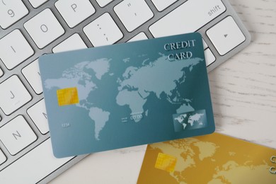 Online payment. Credit cards and keyboard on white wooden table, flat lay