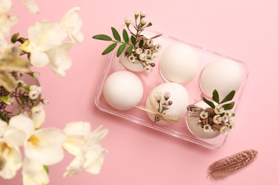 Photo of Festive composition with eggs and floral decor on pink background, flat lay. Happy Easter