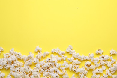 Tasty pop corn on yellow background, flat lay. Space for text