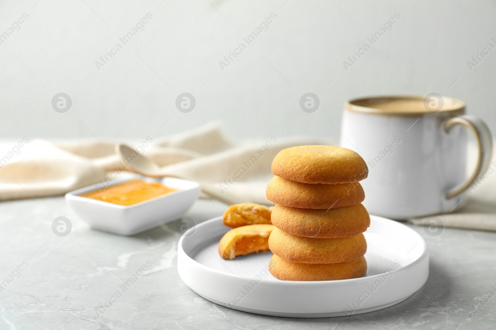 Photo of Tasty shortbread cookies with filling on light grey marble table