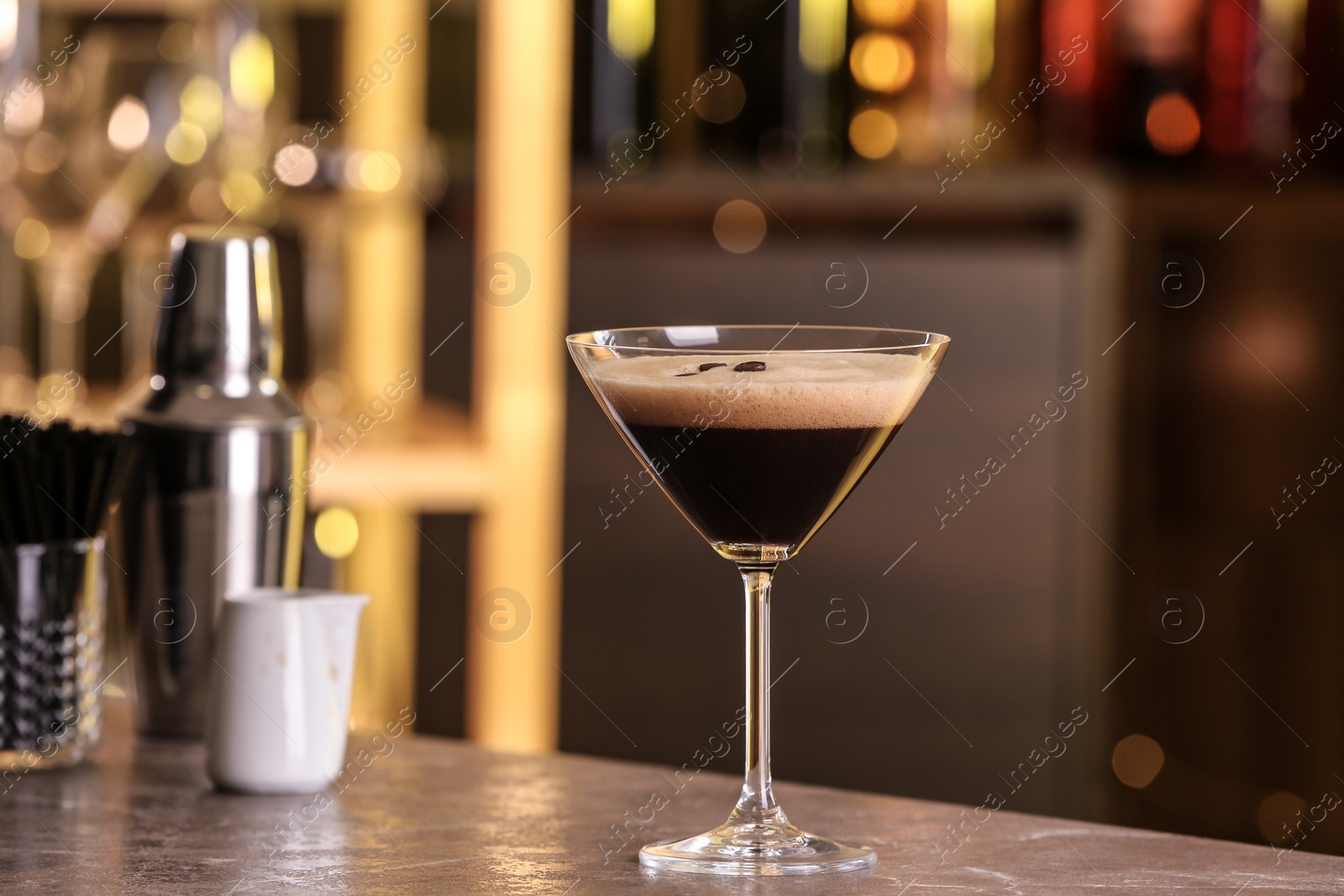 Photo of Glass of delicious Espresso Martini on bar counter. Alcohol cocktail