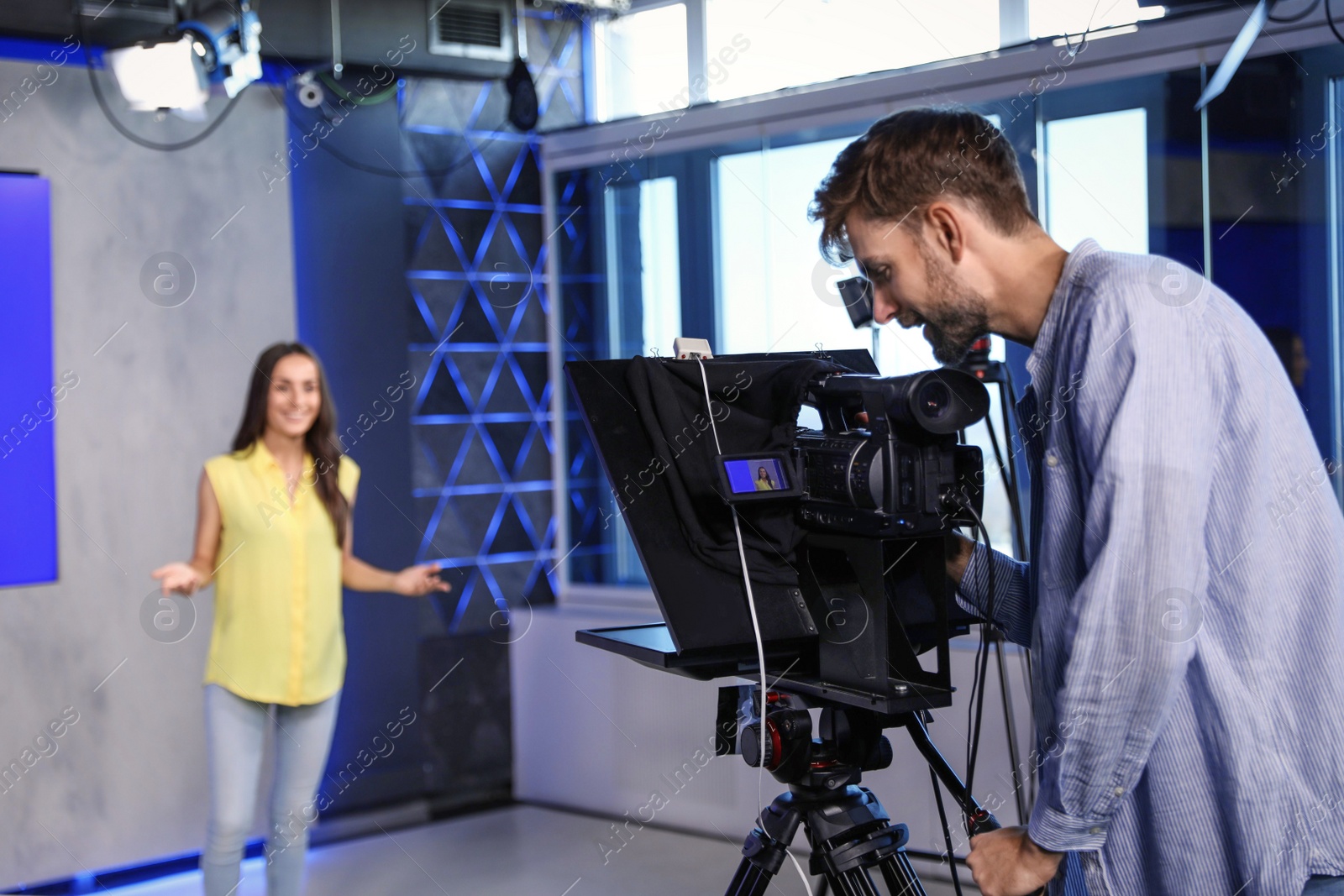 Photo of Professional video camera operator and presenter working in studio