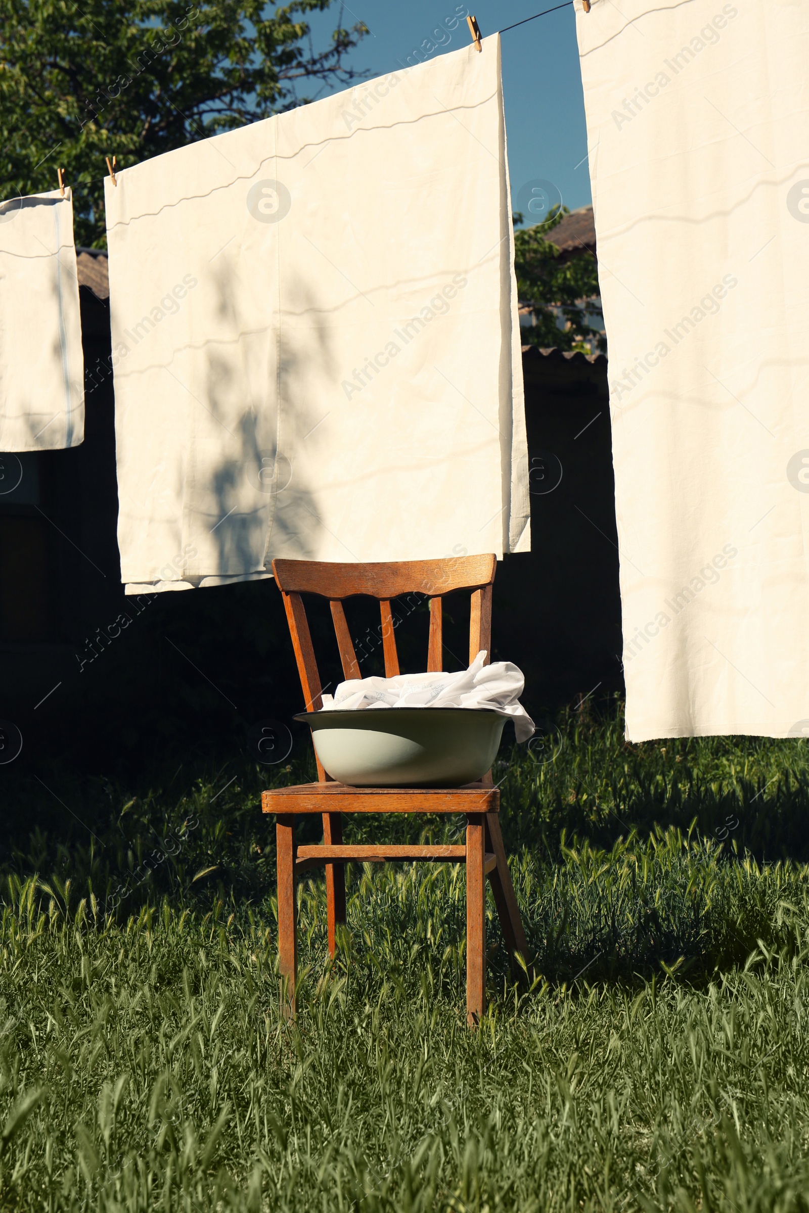 Photo of Washing line with clean laundry and clothespins outdoors