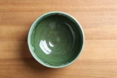 New empty bowl on wooden table, top view