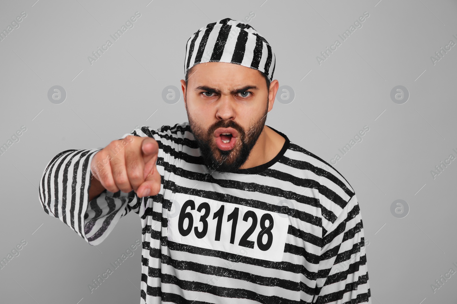 Photo of Emotional prisoner in special uniform on grey background