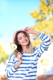 Young pretty girl with candy having fun in park