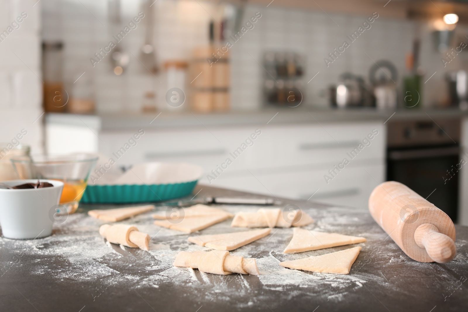 Photo of Composition with ingredients and raw croissants on table in kitchen