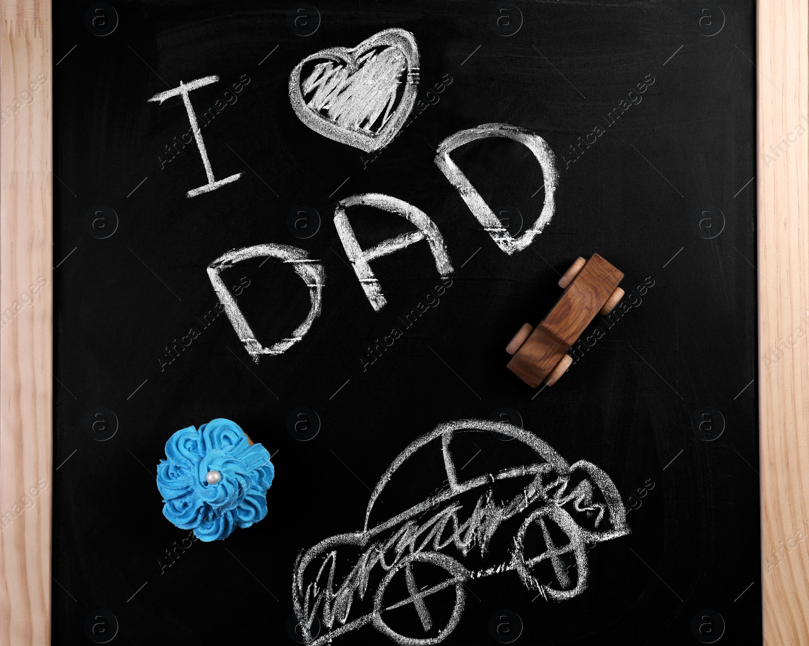 Photo of Phrase "I love dad", cupcake and car on chalkboard. Father's day celebration