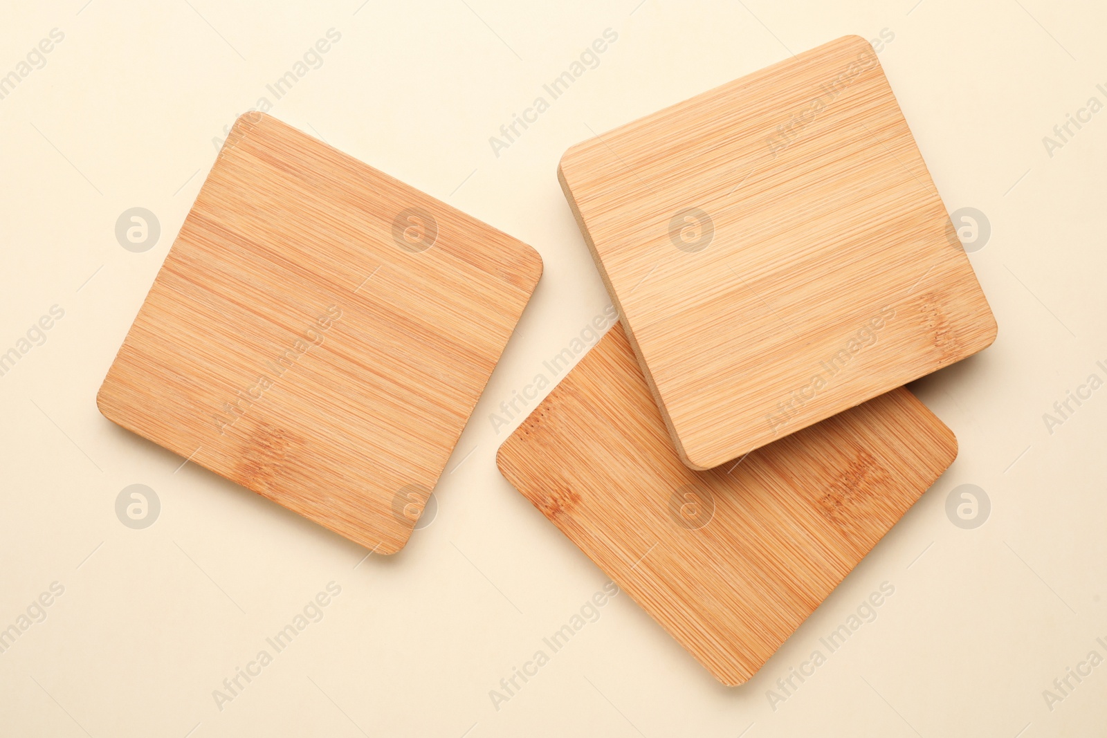 Photo of Stylish wooden cup coasters on beige background, flat lay