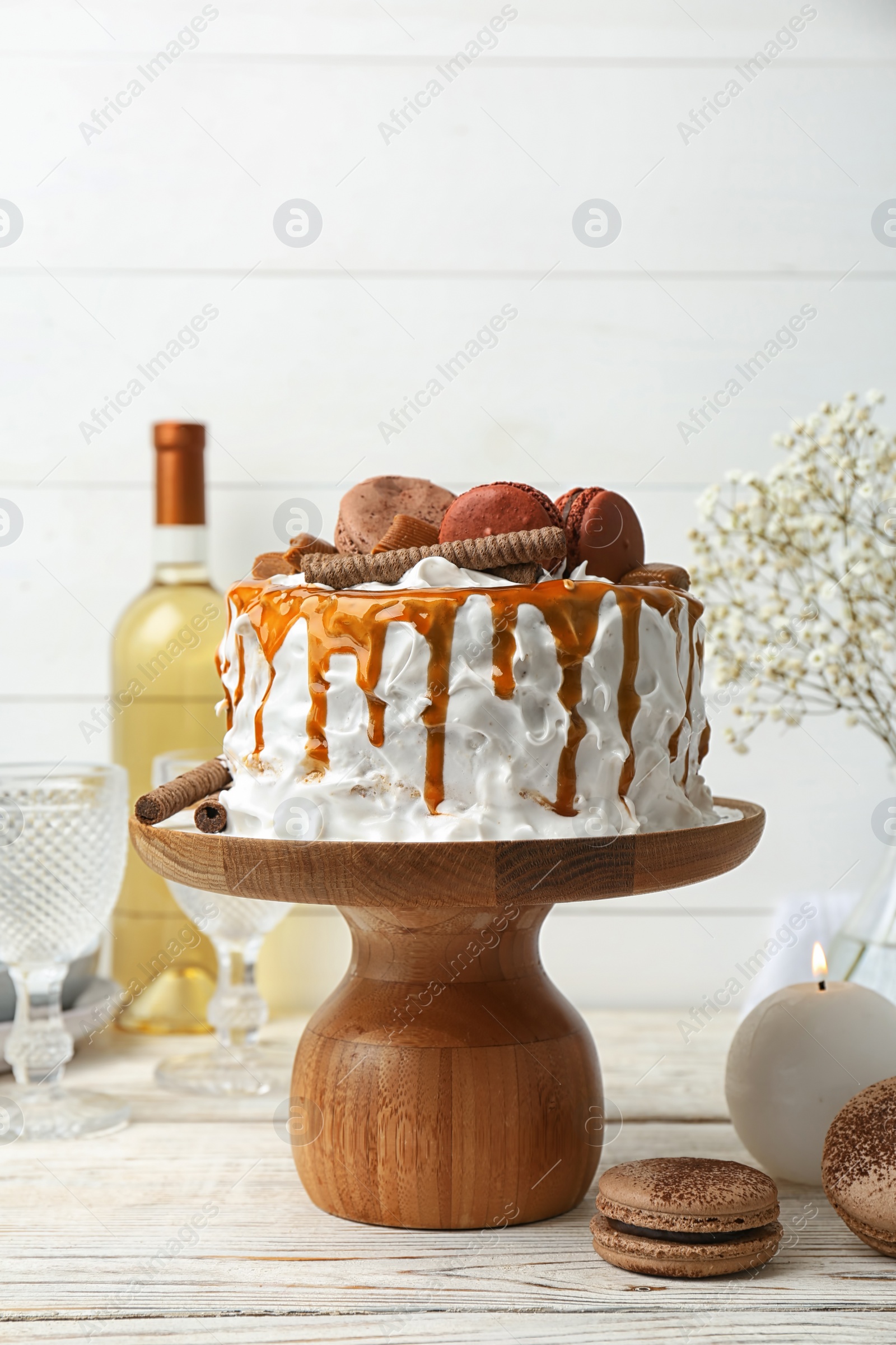 Photo of Delicious homemade cake with caramel sauce and cookies on table