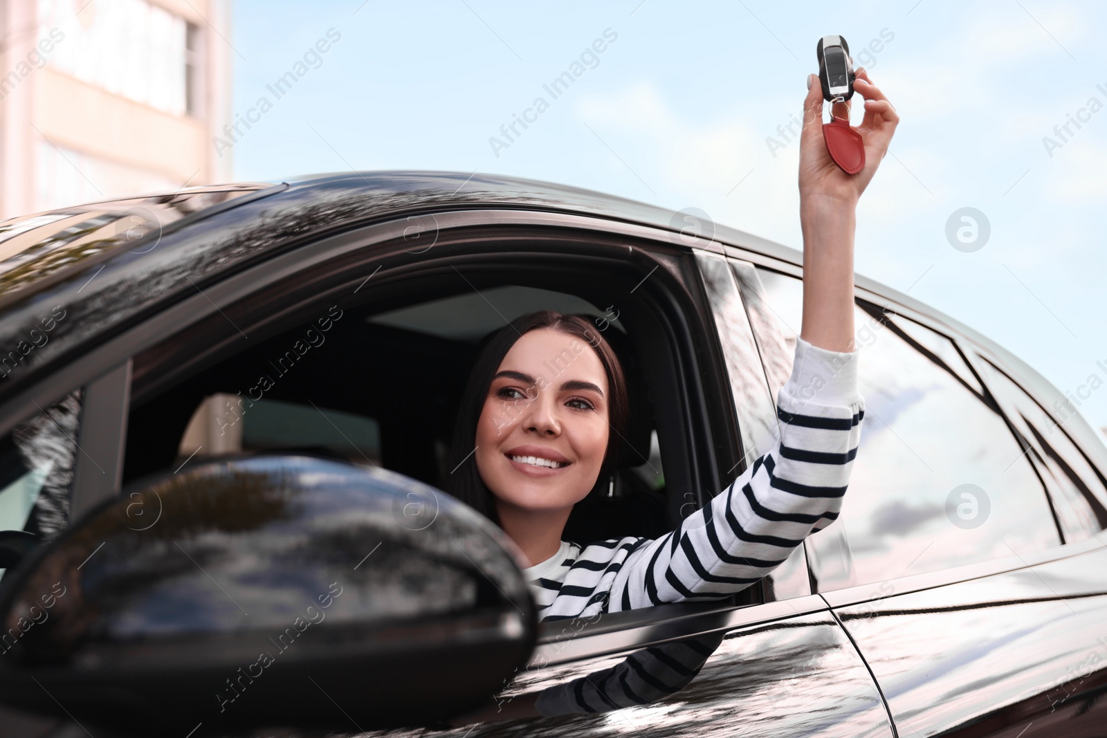 Photo of Woman holding car flip key inside her vehicle