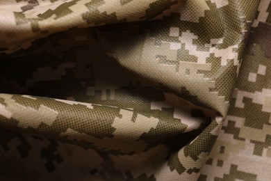 Photo of Texture of crumpled camouflage fabric as background, closeup