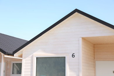 Photo of Number six on beige wooden house outdoors