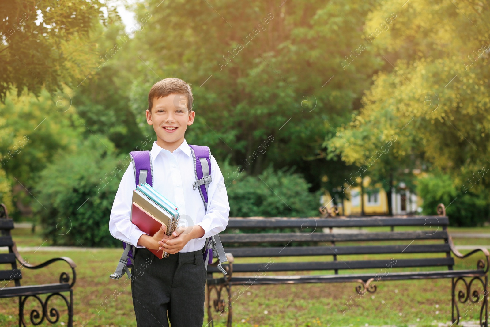 Photo of Cute little school child with stationery in park