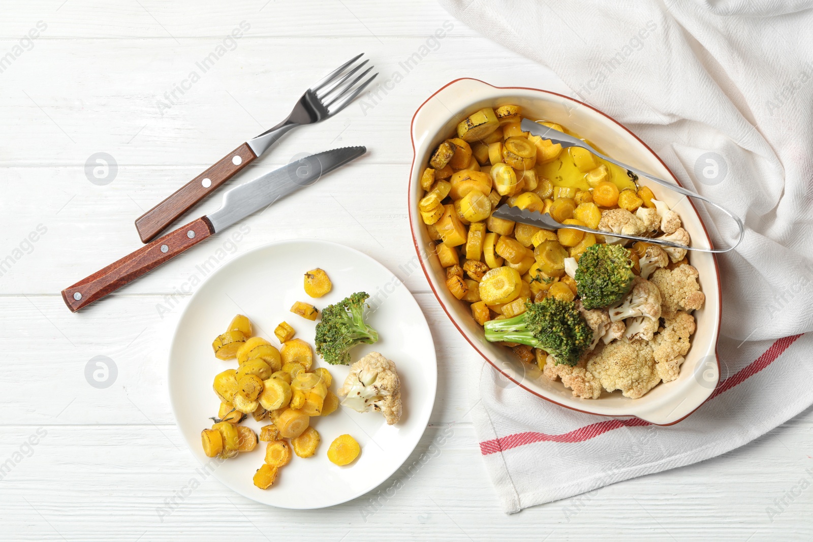 Photo of Flat lay composition with baked yellow carrot on white wooden table