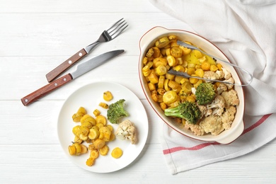 Photo of Flat lay composition with baked yellow carrot on white wooden table