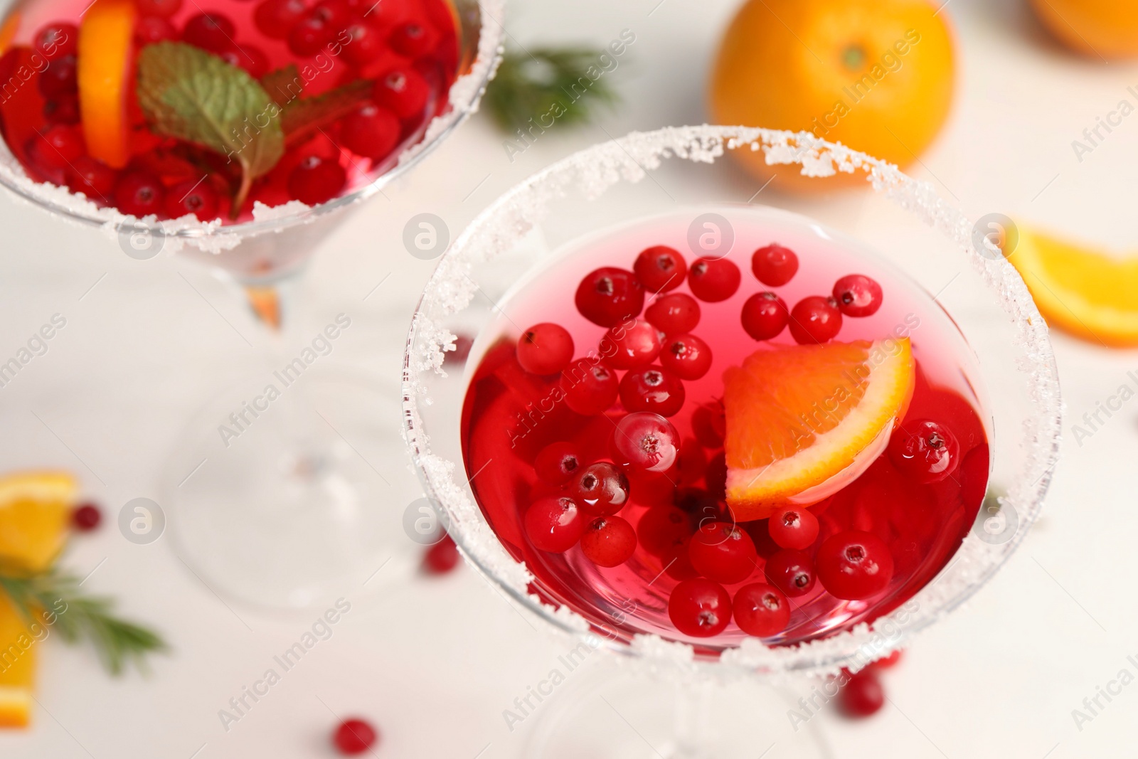 Photo of Tasty cranberry cocktail in glasses on white table, above view