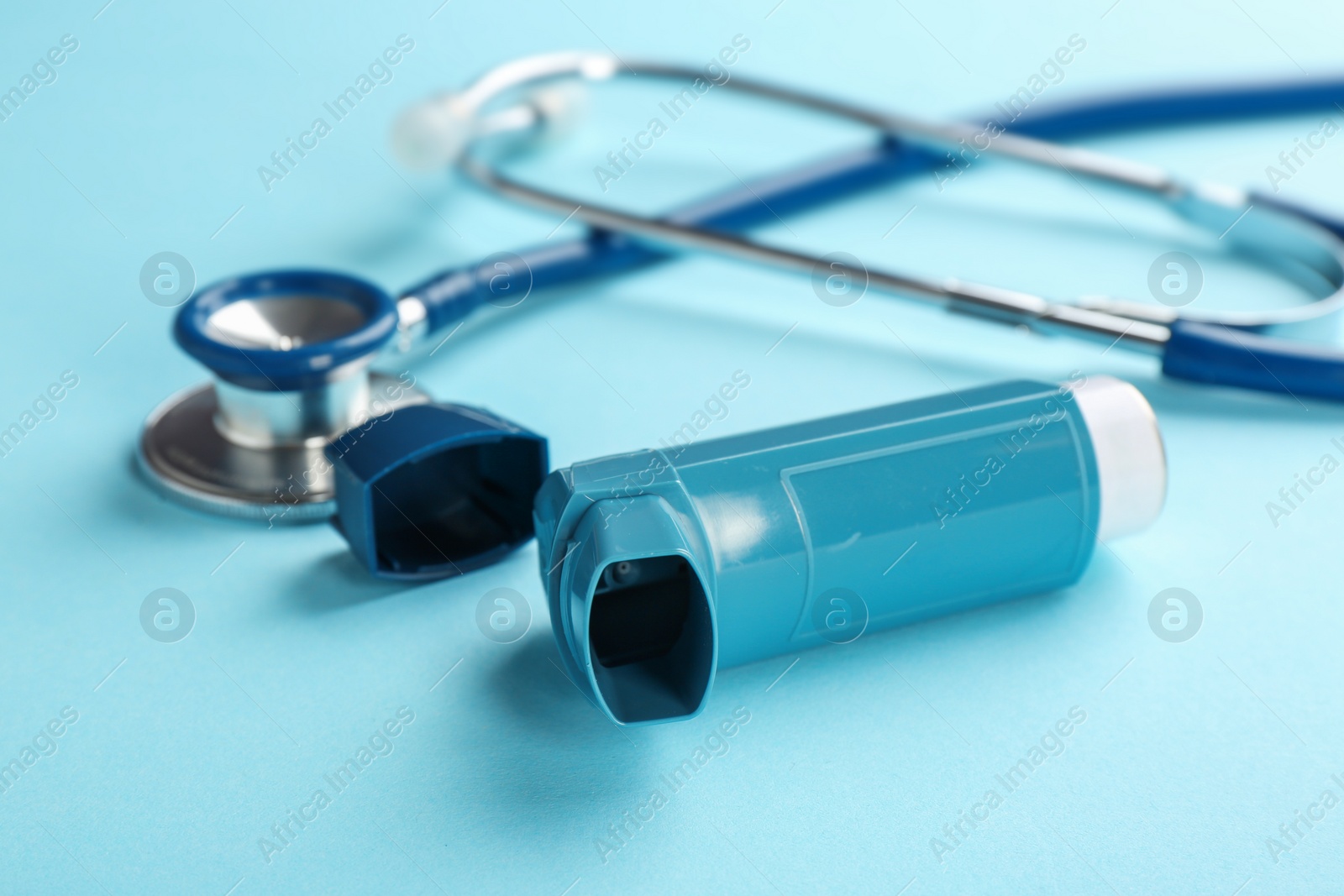 Photo of Asthma inhaler and stethoscope on color background