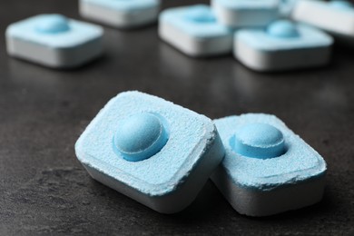 Photo of Water softener tablets on grey table, closeup