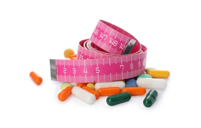 Photo of Weight loss pills and measuring tape on white background