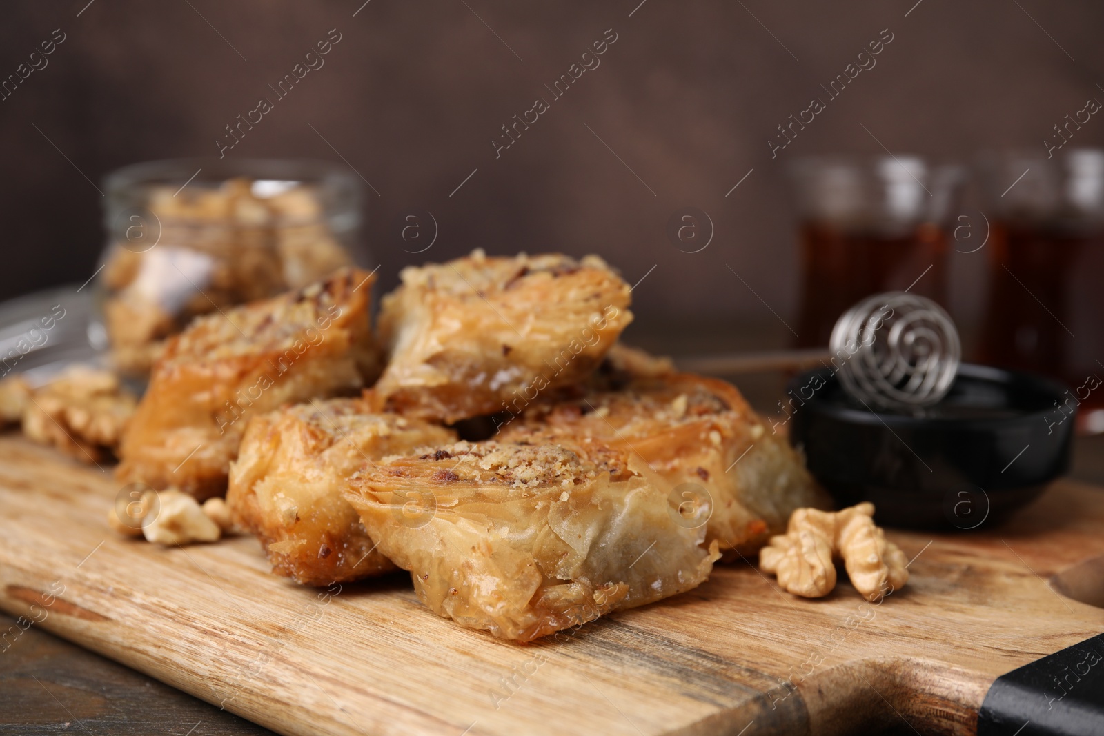 Photo of Eastern sweets. Pieces of tasty baklava on wooden table, closeup