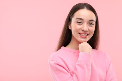 Beautiful woman with clean teeth smiling on pink background, space for text