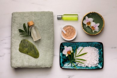 Photo of Flat lay composition with different spa products and flowers on white marble table