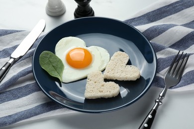 Photo of Romantic breakfast with heart shaped fried egg served on table