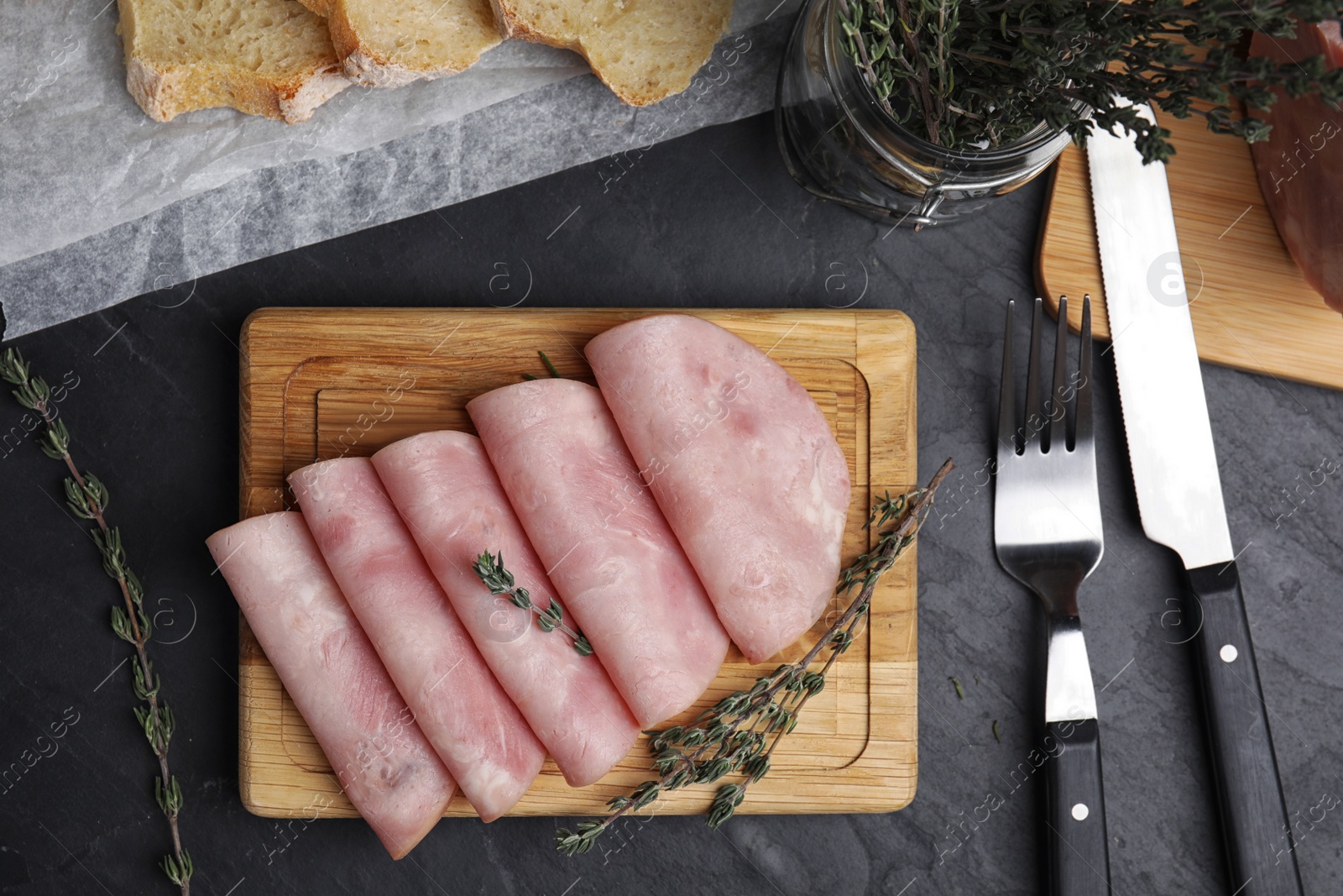 Photo of Tasty ham served on black table, flat lay