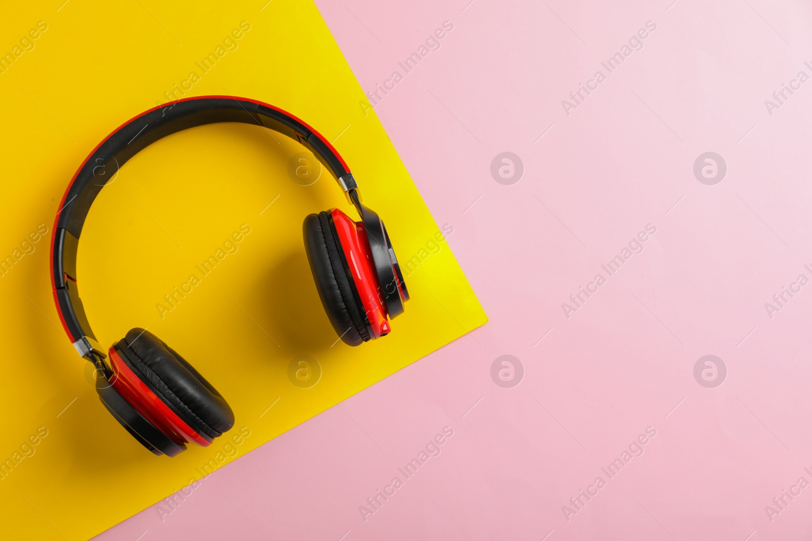 Photo of Wireless headphones on color background, top view. Space for text