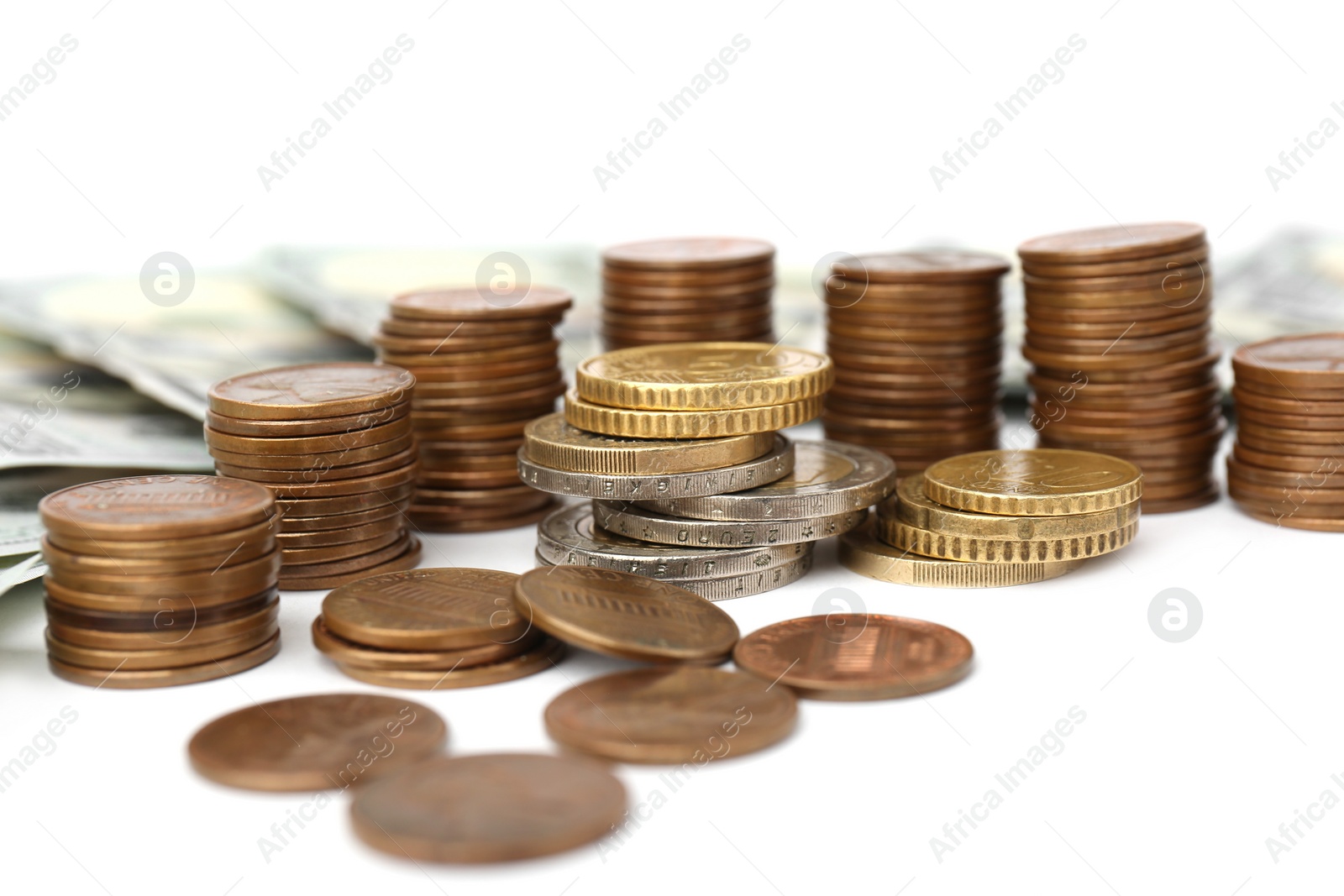 Photo of Dollar banknotes and stacks of coins on white background, closeup