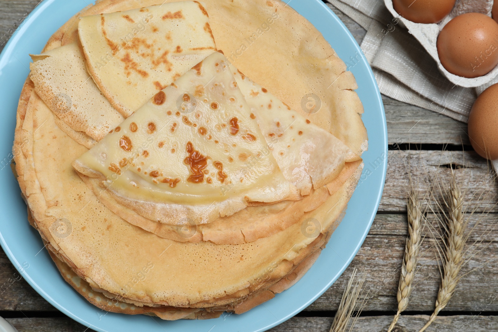 Photo of Delicious crepes and ingredients on wooden table, flat lay