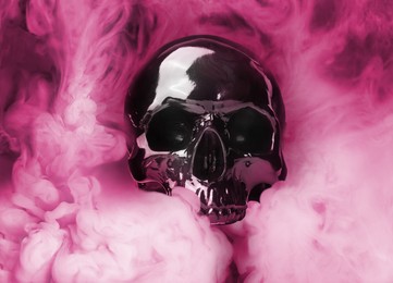 Image of Scary skull emerging from smoke in darkness