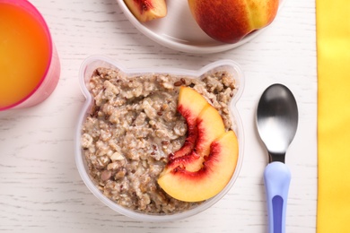Photo of Flat lay composition with oatmeal on white wooden table. Breakfast for kids