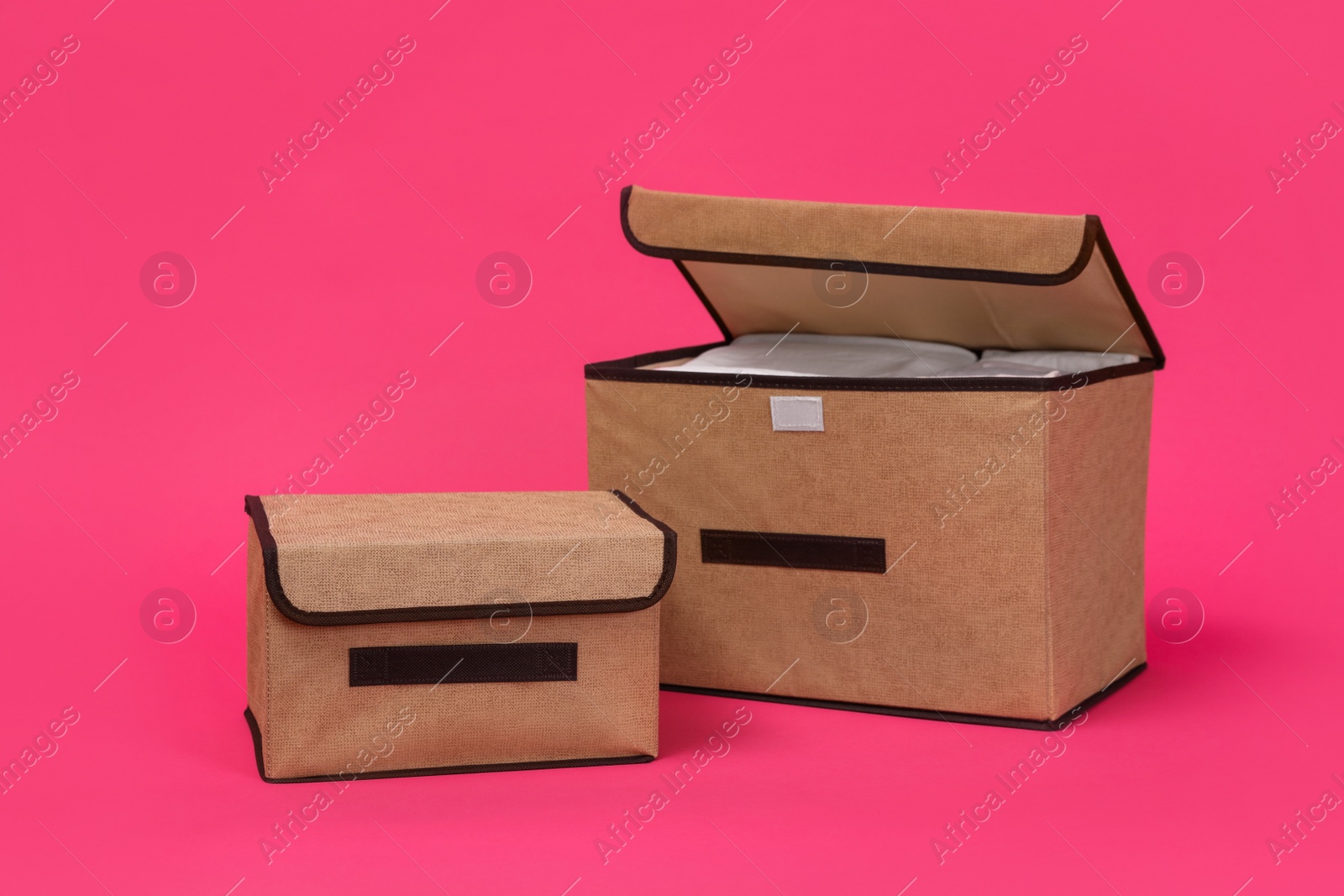 Photo of Two textile storage cases on pink background