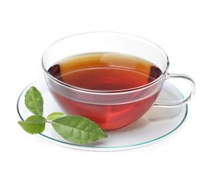 Photo of Glass cup of hot aromatic tea and green leaves on white background