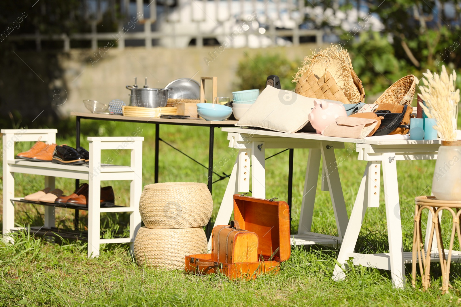 Photo of Small tables with many different items on garage sale in yard