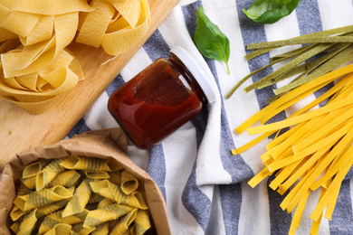 Photo of Flat lay composition with different types of pasta on fabric