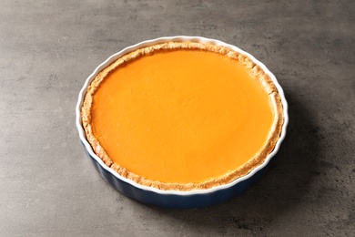 Photo of Fresh delicious homemade pumpkin pie on gray background