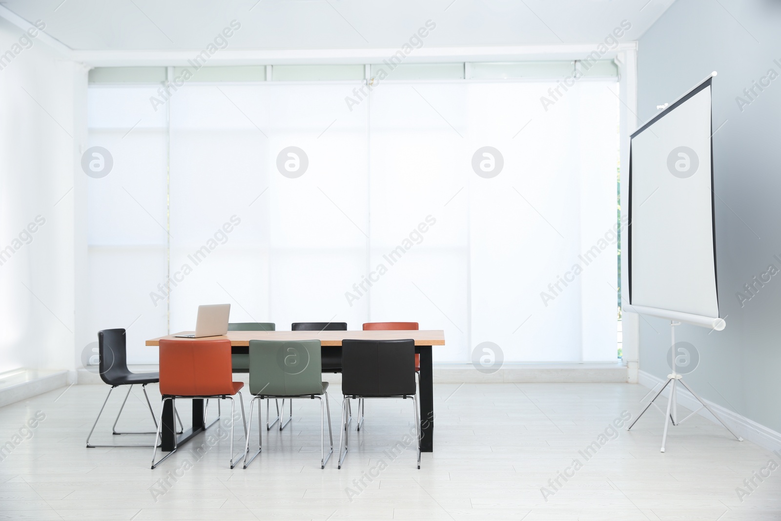 Photo of Conference room interior with wooden table and video projection screen