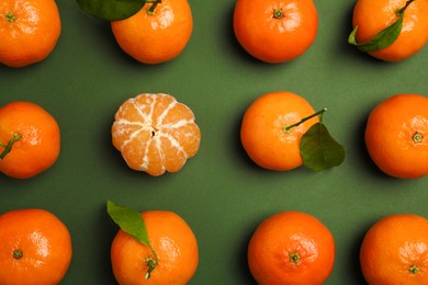 Delicious tangerines and leaves on green background, flat lay