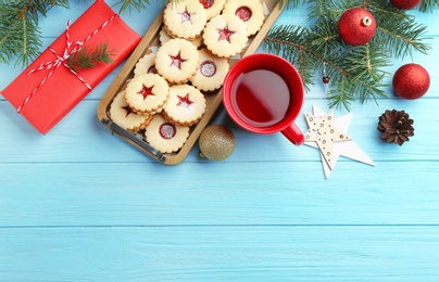 Photo of Christmas items and Linzer cookies with sweet jam on wooden background, top view