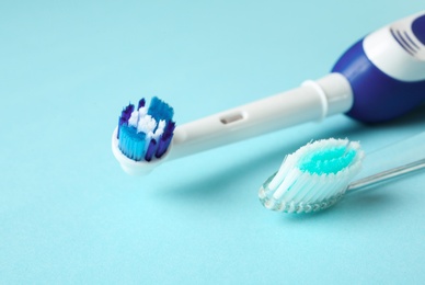 Photo of Manual and electric toothbrushes on color background. Dental care